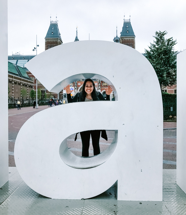 Aliya Bora posing in front of the "A" at the "I Amsterdam" Sign at the Rijksmuseum in Amsterdam, The Netherlands