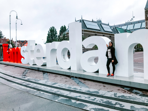 favorite spots in Amsterdam - Aliya Bora posing at the "I Amsterdam" Sign at the Rijksmuseum in Amsterdam, The Netherlands