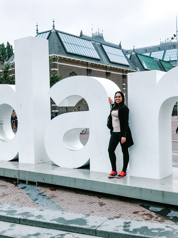 Aliya Bora posing at the "I Amsterdam" Sign in from of the Rijksmuseum in Amsterdam, The Netherlands